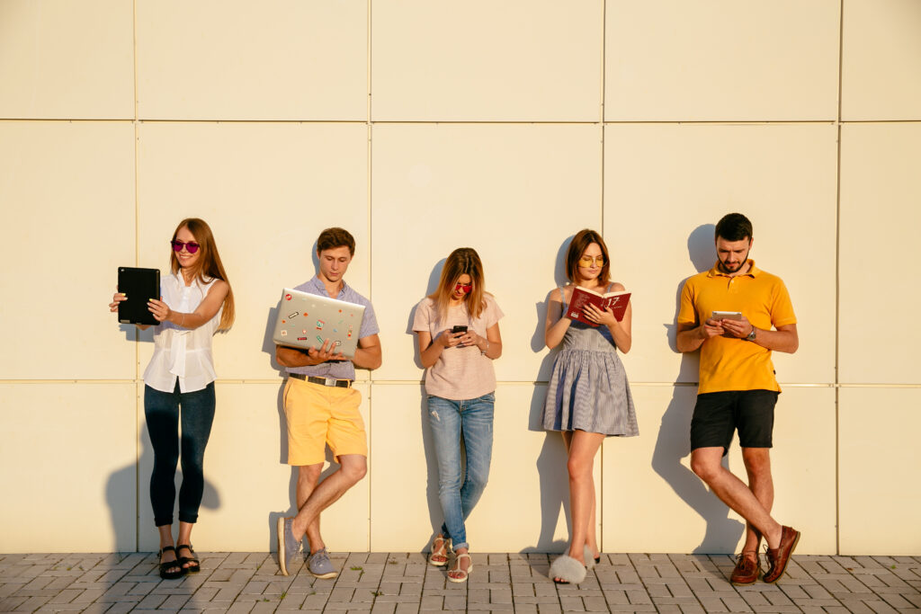 Giovani professionisti della Generazione Z al lavoro con laptop e smartphone